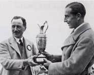 Two really old guys stare at the claret jug like it's their girlfriend.