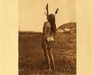 Sun Dance dancer raises his hand towards the sun in ceremony.