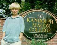 Greg poses for a picture by his college.