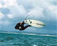 Picture of a kitesurfer riding a wave.