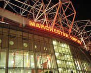 The outsie of Old Trafford at night.